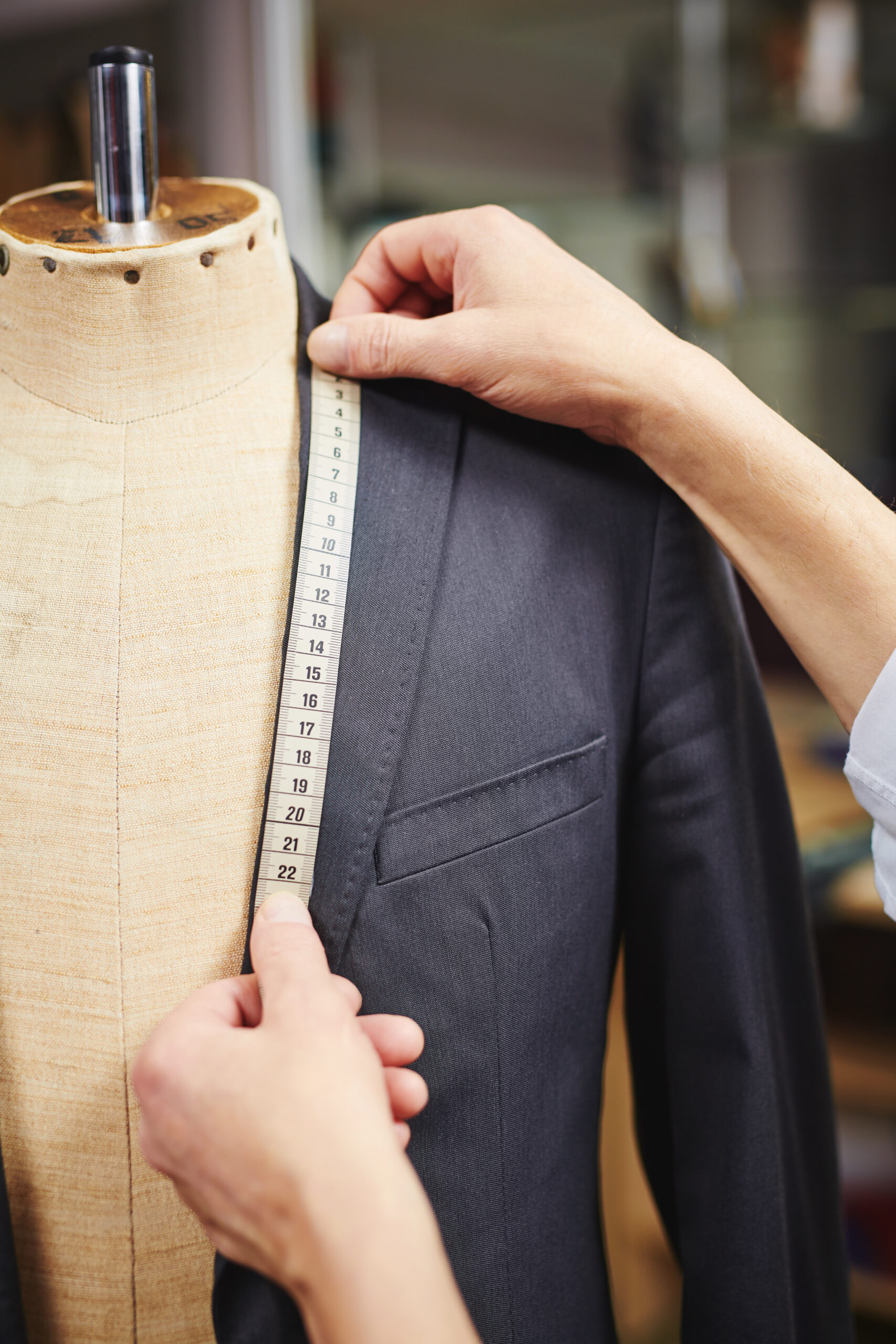 Hands of tailor measuring collar of jacket