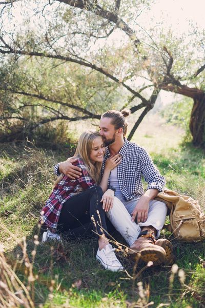 romantic-couple-hugging-sitting-park-wearing-shirt-young-girl-with-her-handsome-boyfriend-with-beard-enjoying-sunny-day